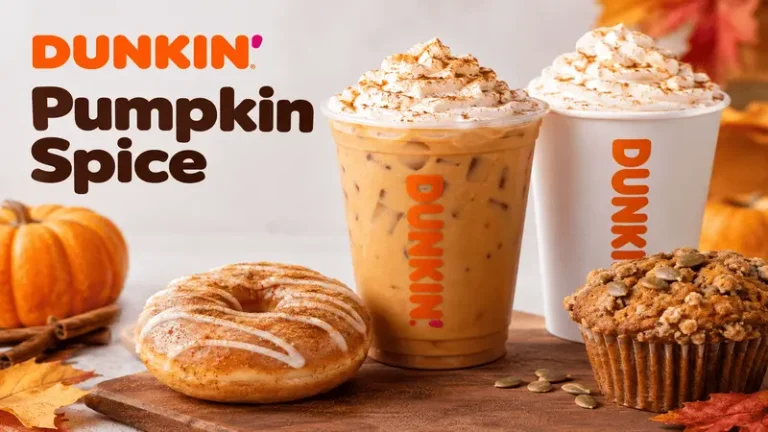 Dunkin Pumpkin Spice drinks, pumpkin donut, and pumpkin muffin on an autumn-themed table.